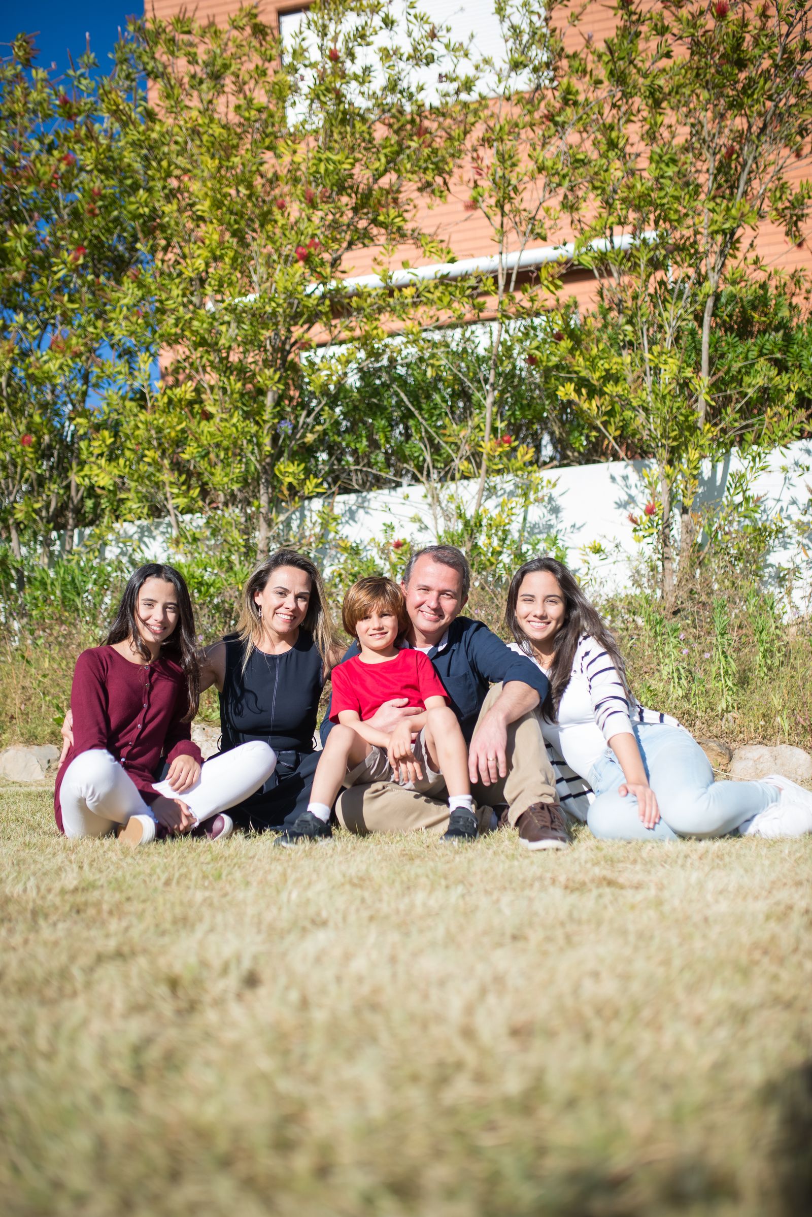 A happy host family with their children smiling together outside their home